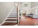 Open-concept living room featuring hardwood floors, a staircase, and an adjoining dining area at 850 Long Branch Cir, Sugar Hill, GA 30518