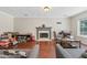 Spacious living room with hardwood floors, gray sofa, fireplace and view to backyard at 850 Long Branch Cir, Sugar Hill, GA 30518