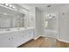 Bright bathroom featuring a double vanity, modern lighting fixtures, and wood-look floors at 955 Mill Creek Ave, Canton, GA 30115
