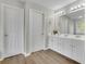 Bright bathroom features a double sink vanity with modern lighting and wood look floors at 955 Mill Creek Ave, Canton, GA 30115