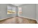 Comfortable bedroom with wood floors, two windows, and neutral decor, perfect for relaxing at 955 Mill Creek Ave, Canton, GA 30115