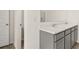 Bathroom featuring dual sinks, vanity with storage and a view of a separate toilet room at 613 Lobelia Way, Locust Grove, GA 30248