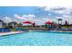 Community pool with a view of the play area and several lounge chairs and umbrellas at 613 Lobelia Way, Locust Grove, GA 30248