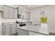 Modern kitchen featuring gray cabinets, granite countertops, stainless steel appliances, and a double sink at 613 Lobelia Way, Locust Grove, GA 30248