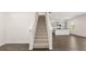 Open-concept living space with a staircase leading upstairs and hardwood flooring at 613 Lobelia Way, Locust Grove, GA 30248
