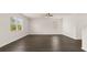 Open living space with hardwood floors, a ceiling fan, and a staircase leading to the second floor at 613 Lobelia Way, Locust Grove, GA 30248