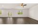 Spacious living room featuring hardwood flooring, a ceiling fan, and ample natural light from large windows at 613 Lobelia Way, Locust Grove, GA 30248