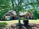 Charming brick home boasts mature trees, manicured lawn, and inviting curb appeal at 6605 New Ridge Court Ct, Cumming, GA 30041