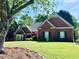 Stunning brick home is accented by lush greenery and a meticulously kept lawn at 6605 New Ridge Court Ct, Cumming, GA 30041