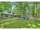 Expansive backyard view of a beautiful home with a patio and mature trees on a sunny day at 1580 Smyrna Sw Rd, Conyers, GA 30094