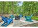 Backyard patio featuring a seating area with colorful Adirondack chairs surrounded by a lush forest at 1580 Smyrna Sw Rd, Conyers, GA 30094