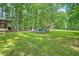 Expansive backyard with lush green grass and a patio nestled within a beautiful wooded landscape at 1580 Smyrna Sw Rd, Conyers, GA 30094