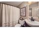 Cozy bathroom showcasing a vanity, decorative mirror, and shower with a charming, neutral-toned curtain at 1580 Smyrna Sw Rd, Conyers, GA 30094