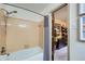 Neutral-toned bathroom with a bathtub, shower, and peek into an adjacent room, creating an open feel at 1580 Smyrna Sw Rd, Conyers, GA 30094