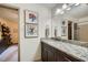 Elegant bathroom featuring a granite countertop vanity, decorative art, and a well-lit mirror at 1580 Smyrna Sw Rd, Conyers, GA 30094