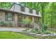 Charming brick home with lush landscaping, a winding staircase, and mature trees at 1580 Smyrna Sw Rd, Conyers, GA 30094