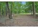 Fenced backyard with trees, offering a private and natural outdoor space at 25 Pebble Creek Dr, Covington, GA 30016