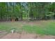 A spacious backyard with lush greenery, mature trees, and a small storage shed at 25 Pebble Creek Dr, Covington, GA 30016