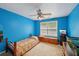 Bright bedroom with blue walls, ceiling fan, and a window providing natural light; includes wooden furniture at 25 Pebble Creek Dr, Covington, GA 30016