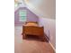A bedroom with an attic ceiling, pink walls, a window, carpeted floors and a bed with orange bedding at 25 Pebble Creek Dr, Covington, GA 30016