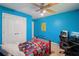 Bright blue bedroom with desk, a bed with colorful quilt, and a window, creating a comfortable living space at 25 Pebble Creek Dr, Covington, GA 30016