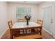 Cozy dining area with a wood table, bench, tile floor, and natural light at 25 Pebble Creek Dr, Covington, GA 30016