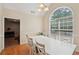 Dining room showcasing an arched window, hardwood floors, and a white table set with chairs at 25 Pebble Creek Dr, Covington, GA 30016