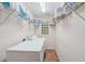 A well-lit laundry room with tile floors, shelving, a window and a white washer and dryer at 25 Pebble Creek Dr, Covington, GA 30016