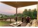 Relaxing covered back deck offers outdoor seating, a grill, and sunset views of the private backyard at 2665 Crowbrook Way, Cumming, GA 30040