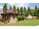 Stone guardhouse and entrance sign to Mountain Crest, nestled amongst trees and lush green landscaping at 2665 Crowbrook Way, Cumming, GA 30040
