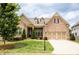 Beautiful brick home with a well-manicured lawn, mature tree, and charming architectural details at 2665 Crowbrook Way, Cumming, GA 30040
