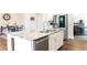 Modern kitchen island with white cabinets, stainless steel appliances, granite countertops, and wood floors at 2665 Crowbrook Way, Cumming, GA 30040