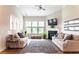 Bright living room featuring a fireplace, large windows, and neutral-toned furniture at 2665 Crowbrook Way, Cumming, GA 30040