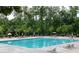 A large rectangular community pool lined with lounge chairs and umbrellas surrounded by lush trees at 2665 Crowbrook Way, Cumming, GA 30040