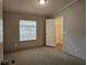 Bedroom with neutral carpet, a window view, a ceiling light and access to a walk-in closet at 85 Holly Dr, Carrollton, GA 30116