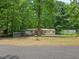 Quaint single-Gathering home surrounded by a wooded landscape and a chain-link fence at 85 Holly Dr, Carrollton, GA 30116