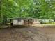 Charming single-story home featuring a cozy front porch and carport nestled among mature trees at 85 Holly Dr, Carrollton, GA 30116