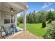 Cozy covered patio with chairs and a fan, overlooking a green lawn with mature trees at 307 Serenity Way, Woodstock, GA 30188