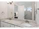 Bathroom with a double sink vanity, granite countertop, and large mirror, with access to tiled shower at 307 Serenity Way, Woodstock, GA 30188