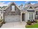 Charming stone and painted brick home with a two-car garage, landscaped yard and inviting entryway at 307 Serenity Way, Woodstock, GA 30188