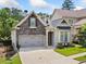 Charming home featuring a stone facade, two-car garage, and a cozy front porch with a bench at 307 Serenity Way, Woodstock, GA 30188