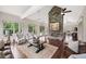 Open-concept living room with a stone fireplace, hardwood floors, and large windows providing natural light at 307 Serenity Way, Woodstock, GA 30188