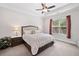 Bright main bedroom featuring a queen-size bed, ceiling fan, bedside tables, and a sunlit window at 307 Serenity Way, Woodstock, GA 30188