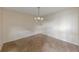 A dining room with neutral walls and flooring illuminated by a modern chandelier at 346 Carpenter Dr # 70, Atlanta, GA 30328