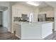 Bright kitchen features white cabinets, stainless appliances, gray tile backsplash, and large island at 502 Helene Ct, Woodstock, GA 30188