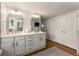 Well-lit bathroom featuring double sinks, a large mirror, and ample cabinet space at 522 Trabert Nw Ave, Atlanta, GA 30309