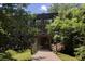 Covered wooden bridge entrance surrounded by lush green trees and foliage at 522 Trabert Nw Ave, Atlanta, GA 30309