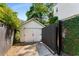 Spacious detached garage with white doors, surrounded by lush greenery and a black fence at 522 Trabert Nw Ave, Atlanta, GA 30309