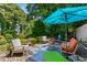 Relaxing patio area with comfortable seating, colorful umbrella, surrounded by lush greenery at 522 Trabert Nw Ave, Atlanta, GA 30309