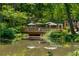 Scenic pond view with a wooden bridge, lush greenery, and a playground in the background at 522 Trabert Nw Ave, Atlanta, GA 30309